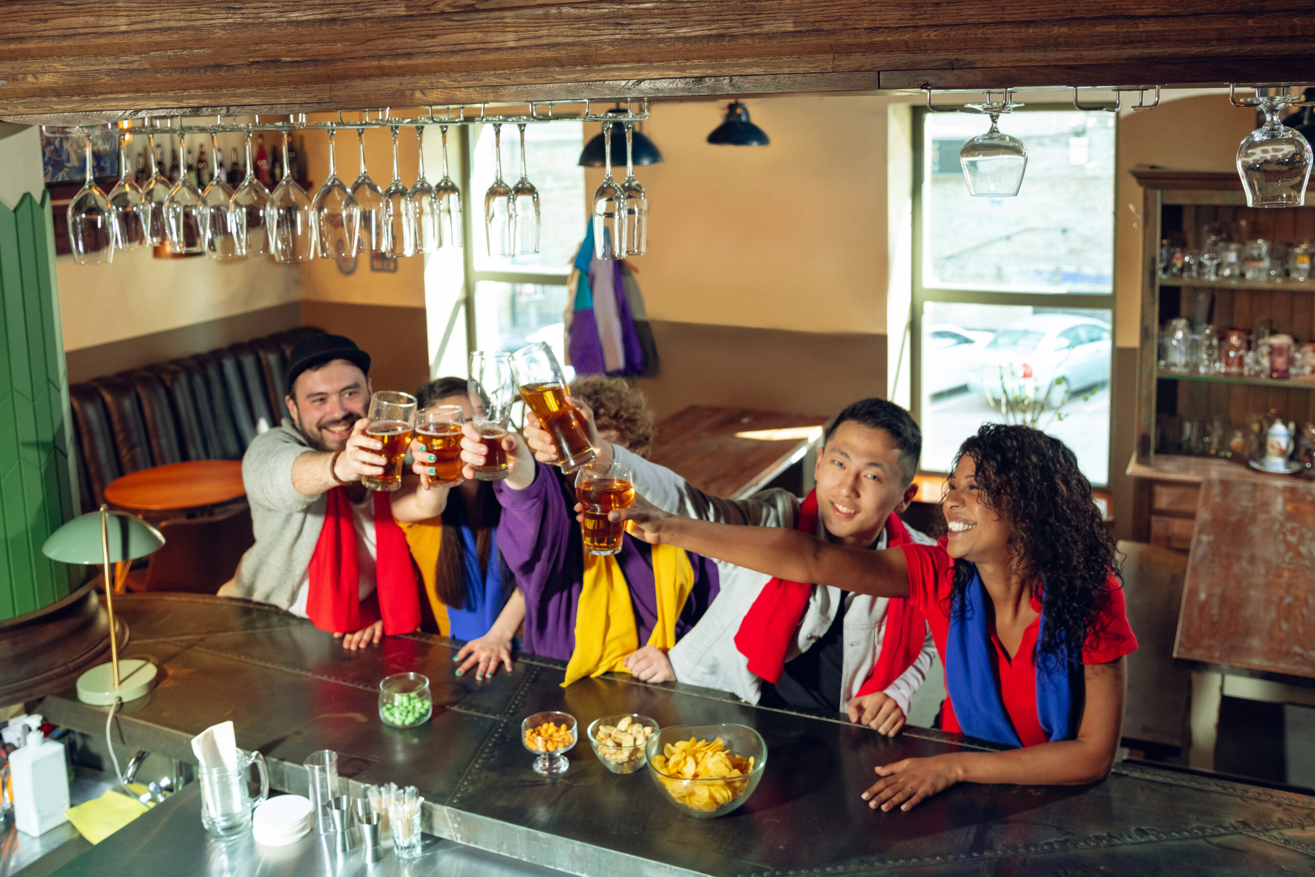 Sport fans cheering at bar, pub and drinking beer while championship, competition is going